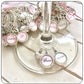 Pink and white bride wine glass charms with a heart.