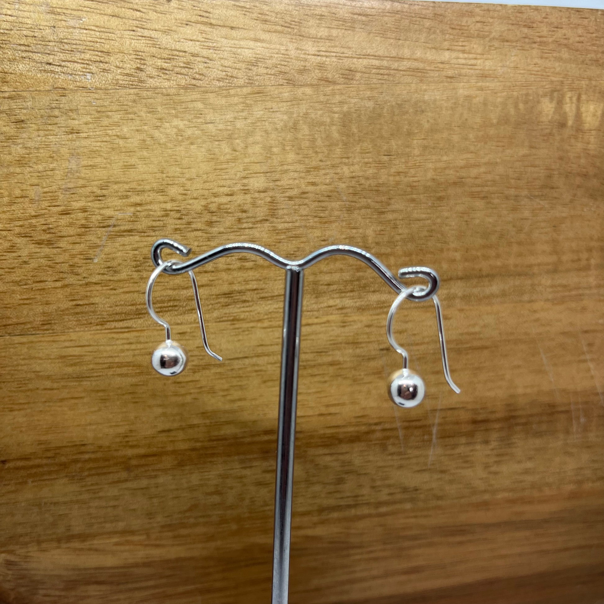 Sterling silver 6mm balls on hooks on a earring stand.