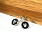 silver metallic hearts on a black background glass dome earrings
